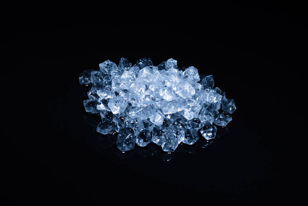 Ice crystal cubes on a black background, space for text or design. - Foto, imagen