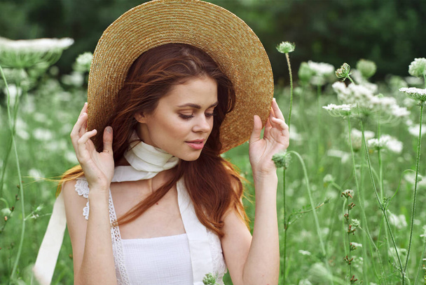 pretty woman in white dress and hat posing flowers nature - Foto, imagen