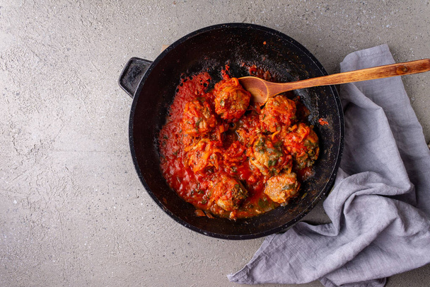 Meatballs in tomato sauce in a frying pan on a gray background copy space - Fotoğraf, Görsel