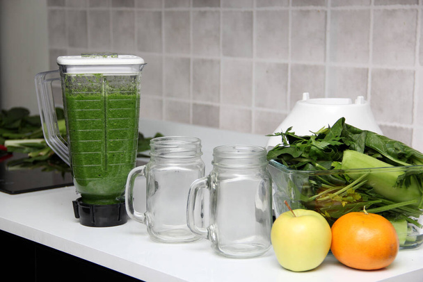 Serveer groene sap in metselaar pot net gemaakt in de keuken blender met ingrediënten zoals komkommer, snijbiet, spinazie, selderij voor een voedzaam ontbijt - Foto, afbeelding