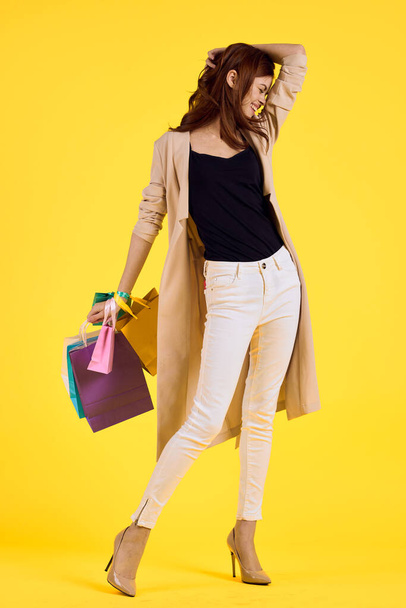 cheerful woman with packages in hands Shopaholic studio model - Fotoğraf, Görsel