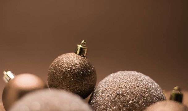 Weihnachtsurlaub und festliche Dekoration Konzept. Goldene Kugeln auf beigem Hintergrund - Foto, Bild
