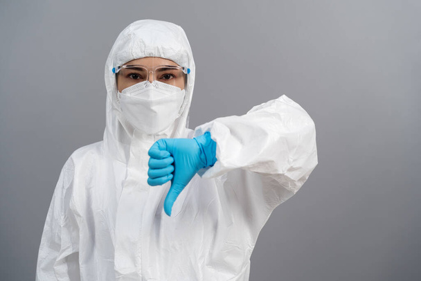 doctor in protective PPE suit doing thump down hand sign - Фото, зображення