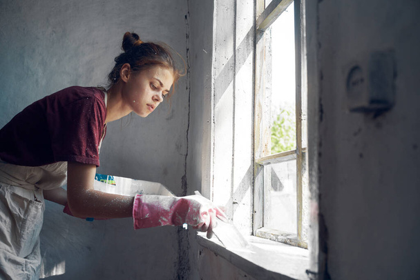 woman painter paints window with brush renovation interior decoration - Valokuva, kuva