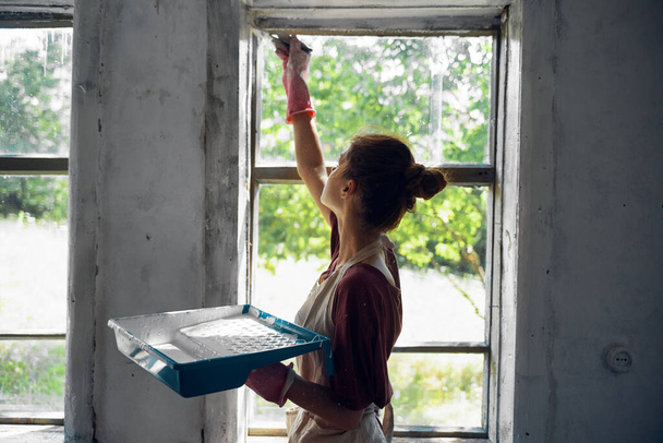 woman paints windows in the house interior room renovation - 写真・画像