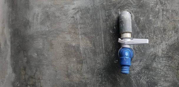 кран для воды на бетонной стене - Фото, изображение