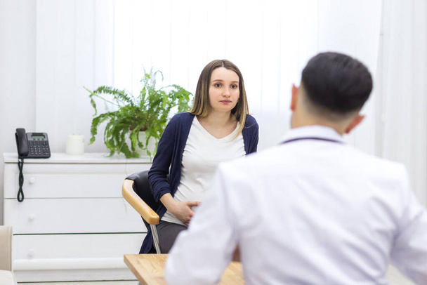 Photo of pregnant woman speaking with a doctor. - Valokuva, kuva