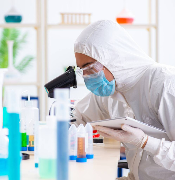 Young chemist student working in lab on chemicals - Photo, image