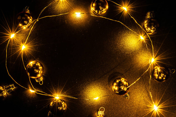 Weihnachtsbeleuchtung grenzt an. Goldener Lichterkranz Dekoration, goldene Glühbirne isoliert auf schwarz für Weihnachtsfeier Schmuck Dekor Hintergrund. Leuchtende Lichter zum Weihnachtsfest - Foto, Bild