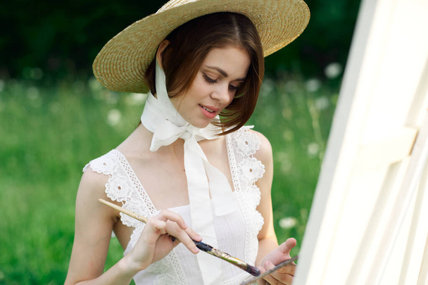 woman artist view with paint palette draws a picture in nature - Fotografie, Obrázek