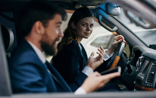 business man and woman driving a car provision of services - Foto, Imagen