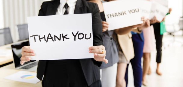 Eine Gruppe von Geschäftsleuten vereint Grußworte und Dankesworte für ein Zeichen der Dankbarkeit gegenüber jemandem in einem modernen Büro. Idee für gutes Teamwork-Gefühl und Unterstützung für Kollegen. - Foto, Bild