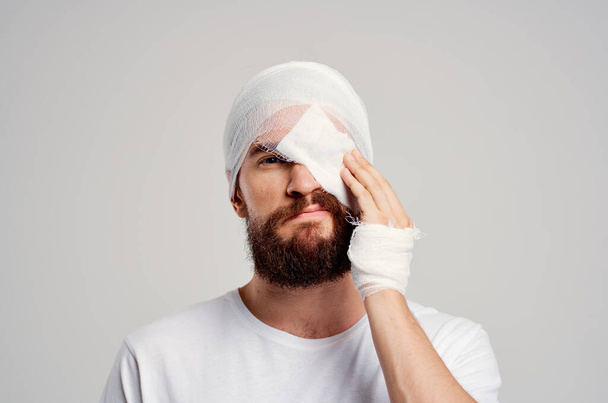 chory człowiek z zabandażowaną głową i oko hospitalizacji lekkie tło - Zdjęcie, obraz
