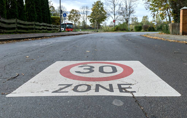 30 km / h nopeusrajoitusliikennemerkki, joka on maalattu tielle koulualueelle Saksassa - Valokuva, kuva