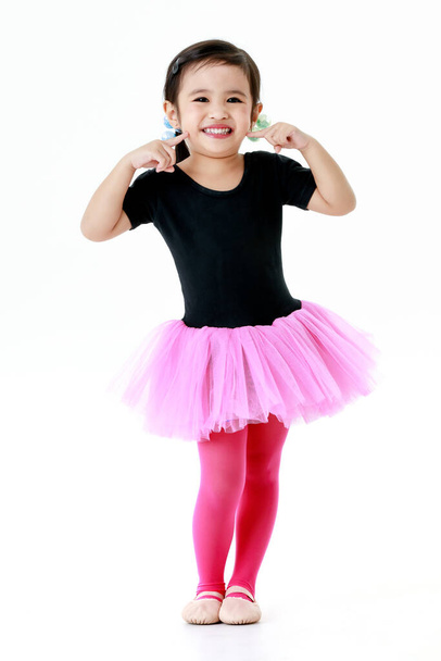 Portrait isolated studio shot of little cute preschool kindergarten ballerina dancer girl in pink tutu ballet dress legging and shoes costume standing posing practice dance in front white background. - Foto, imagen