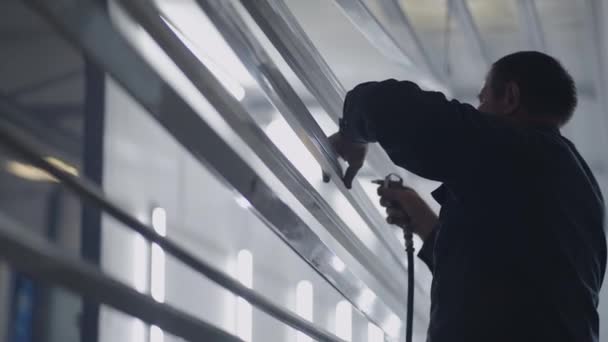 Pracownik i warsztat Molar przetwarza profile stalowe z pyłu i cząstek stałych przed malowaniem w zwolnionym tempie - Materiał filmowy, wideo