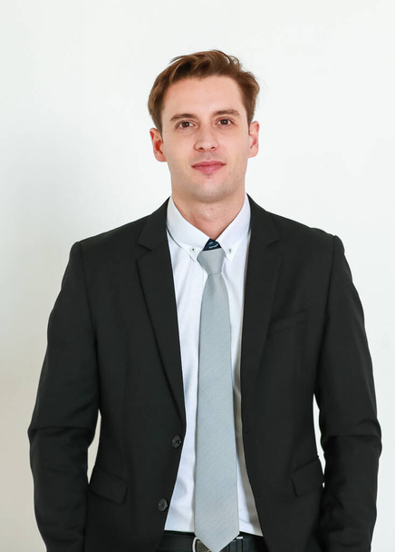 Portrait photo of young businessman in black suit studio shot isolated on white background looking straight at camera with confidence and positvie smile on happy face. Concept for modern man. - Foto, immagini