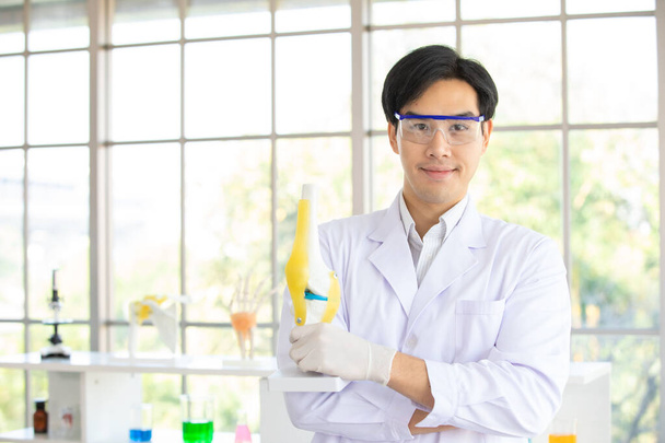 Kuva on muotokuva. Aasialainen mies tiedemies tai tutkija yllään valkoinen takki ja suojaava lasi tilalla keinotekoinen luu tutkimukseen laboratoriossa tai sairaalassa. Käsite tutkimus luu ihmisen - Valokuva, kuva