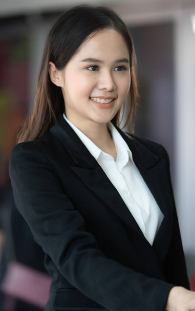 Business woman in a black suit is holding her hand to the other businessman. When the deal was successful In communicating ideas, business ideas - 写真・画像