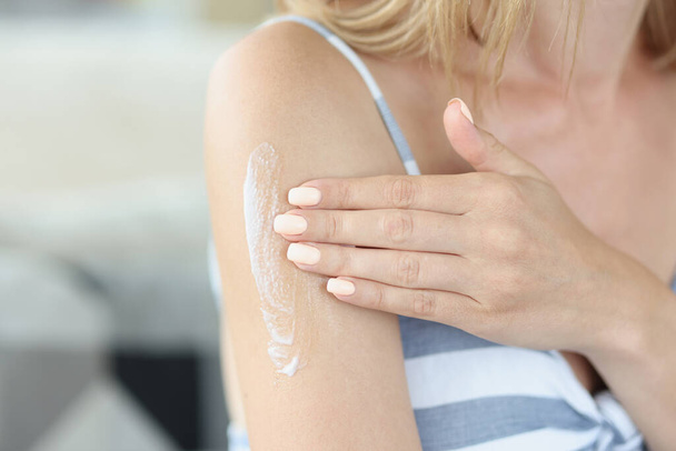 Young woman applying gently moisturizing body lotion on arm - Valokuva, kuva