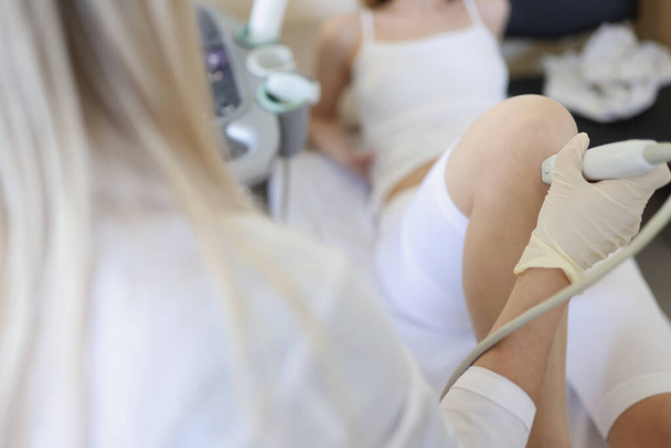 Ženský lékař provádějící ultrazvukové vyšetření pacientů s kolenem na klinice - Fotografie, Obrázek