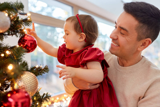 happy father and baby girl decorate christmas tree - Zdjęcie, obraz