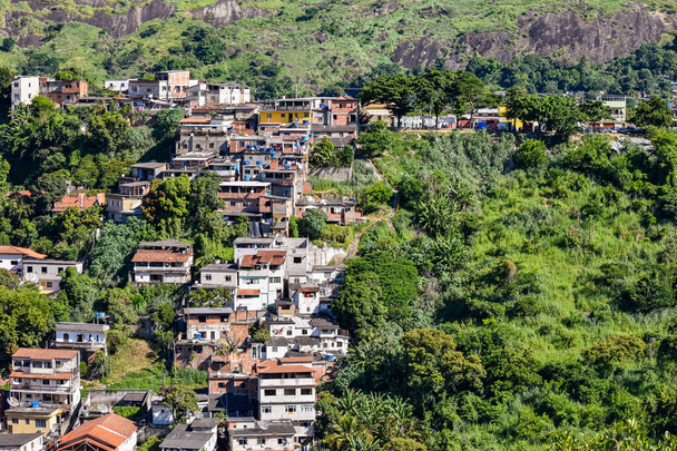 Favelaksi kutsutut yhteisöt ovat kaupunkialueita, joille on ominaista epävarma asuminen ja heikko kaupunkiinfrastruktuuri. Niiden katsotaan johtuvan maan huonosta tulonjaosta ja asuntovajeesta. Kuva otettu Rio de Janeirossa, Brasiliassa. - Valokuva, kuva