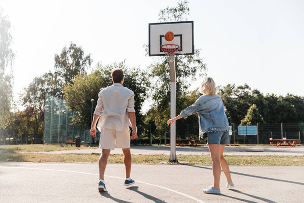 happy couple playing on basketball on playground - Foto, Imagem