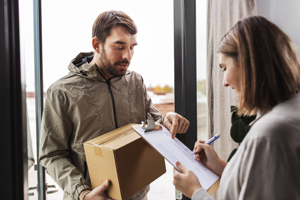 delivery man with parcel box and customer at home - Foto, imagen
