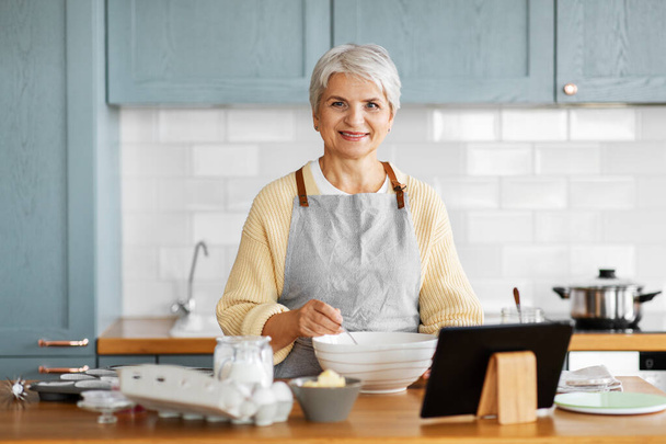 woman with tablet computer cooking food on kitchen - Foto, Imagem