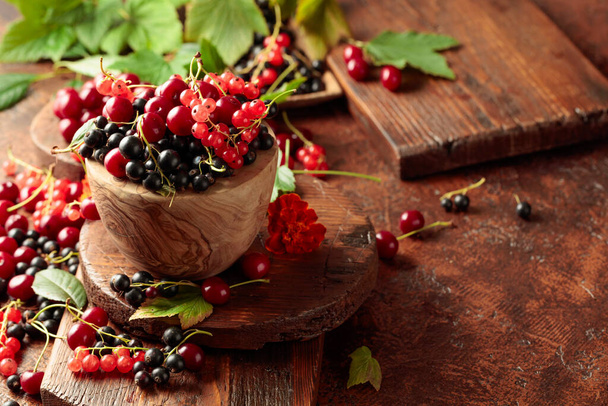 キッチンテーブルの上のチェリー、赤と黒のスグリ。葉でジューシーな果実を熟す. - 写真・画像