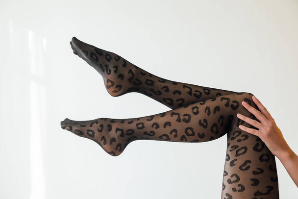 gyönyörű karcsú nők lábak fekete harisnya, mint a háttér - Fotó, kép