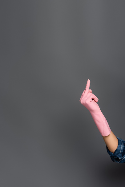 Vista cortada de encanador em luva de borracha mostrando gesto do dedo médio em cinza  - Foto, Imagem