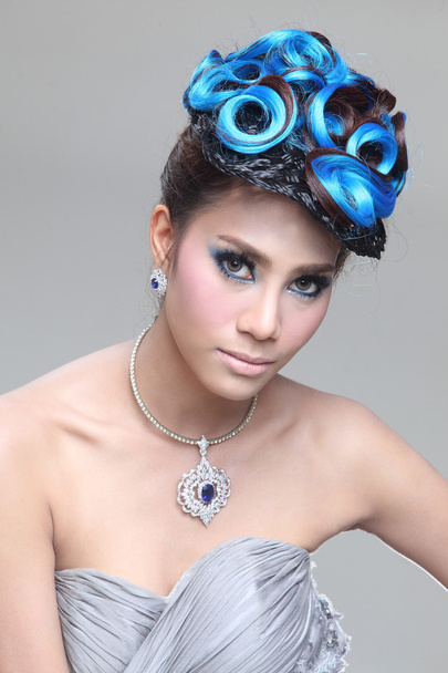 Elegant fashion brunette Thai woman posing with creative chignon hair-style - Photo, image