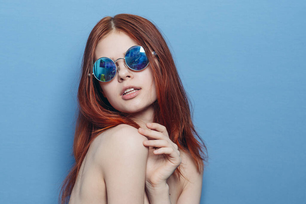 vivace donna dai capelli rossi in occhiali blu spalle nude in posa - Foto, immagini