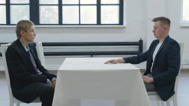 Erschießung zweier Männer, die sich am Tisch gegenübersitzen - Filmmaterial, Video