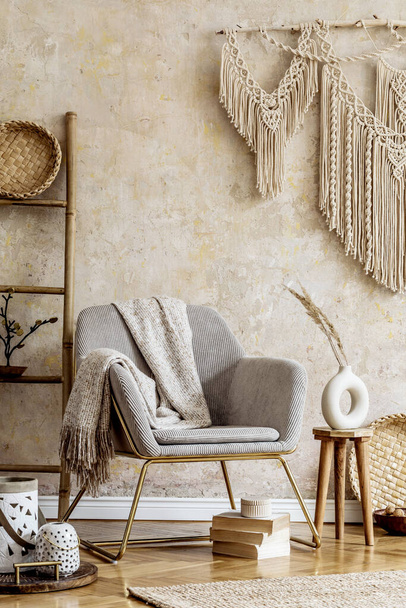 Stylish oriental living room with design armchair, beautiful macrame, wooden ladder, plant, decoration, carpet, coffee table, book and elegant personal accessories in wabi sabi concept. - Valokuva, kuva