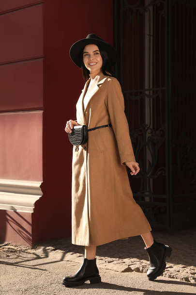 Beautiful young woman with stylish waist bag on city street - Zdjęcie, obraz