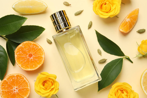 Flat lay composition with bottle of perfume and fresh citrus fruits on beige background - Valokuva, kuva