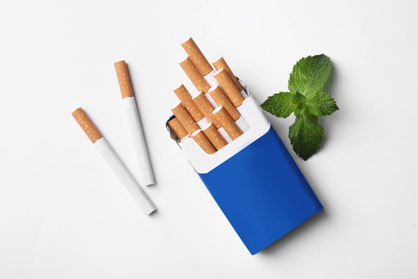 Menthol cigarettes and mint on white background, flat lay - Foto, afbeelding
