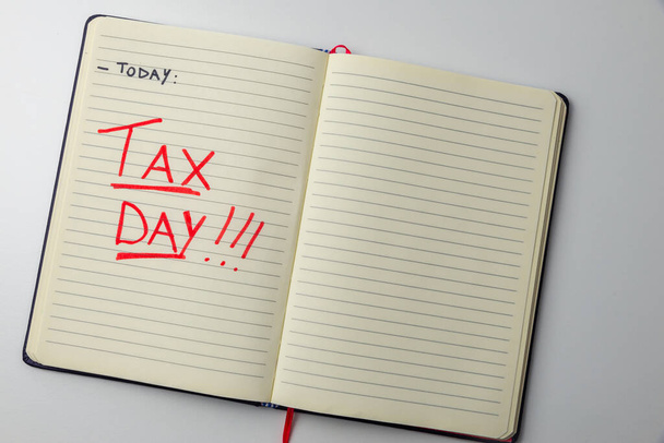 Page of diary or agenda, with the text "today ... tax day", and money next to it. Deadlines and tax obligations. Tax increase. - Photo, Image