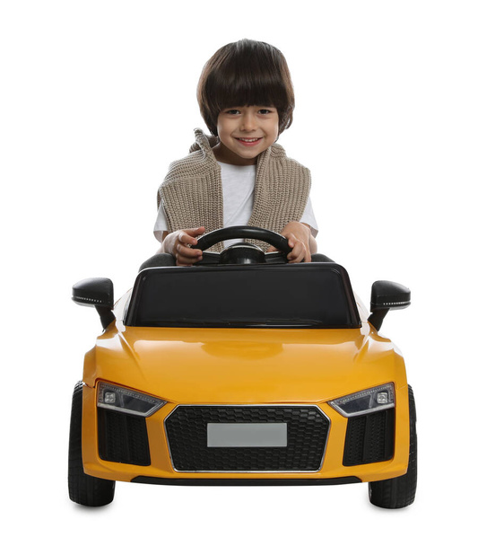 Cute little boy driving children's electric toy car on white background - Fotografie, Obrázek