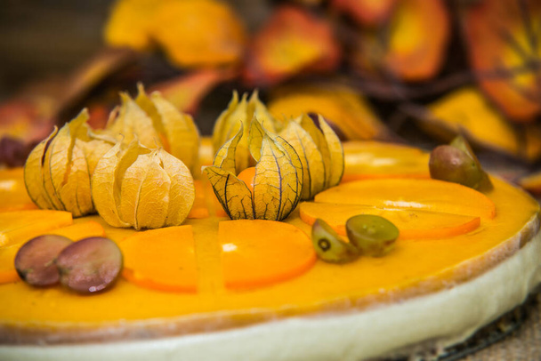 Light delicious yogurt cheesecake with physalis, orange and grapes . Close up - Foto, imagen