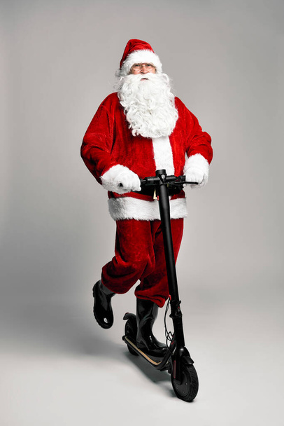 Caucasiano Papai Noel montando uma scooter elétrica - Foto, Imagem