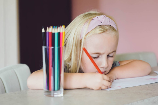 Cute girl drawing with color pencils. Home schooling and education concept. - Photo, Image