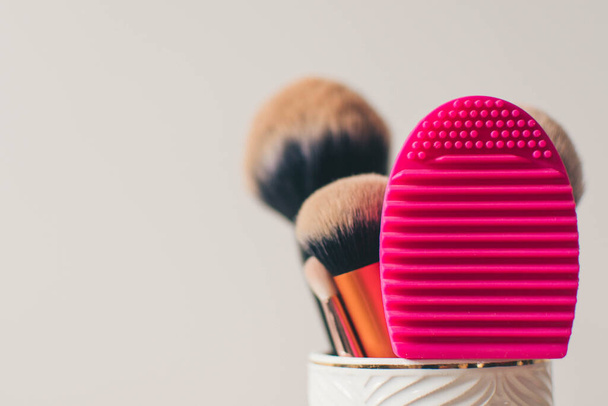 Σύνολο από βρώμικες βούρτσες μακιγιάζ έτοιμες για βαθύ καθαρισμό, απομονωμένες σε λευκό φόντο. επαγγελματικό make up πινέλα και βούρτσα σιλικόνης καθαριστικό μαξιλάρι - Φωτογραφία, εικόνα