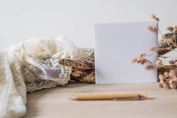 Vintage brown envelope and dried flowers on white material background - Photo, Image