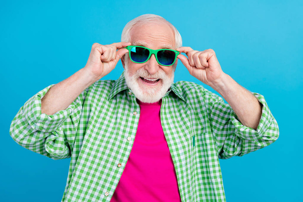 Photo of positive retired cheerful old grandparent wear cool sunglass enjoy summer isolated on blue color background - Фото, изображение
