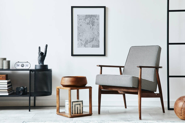 Stylish scandinavian composition of living room with design armchair, black mock up poster frame, commode, wooden stool, book, decoration, loft wall and personal accessories in modern home decor. - 写真・画像