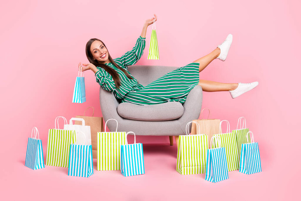 Full size profile side photo of young cheerful girl sit lounger enjoy shopping boutigue wardrobe isolated over pastel color background - Photo, Image